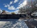 Attractive stucco home featuring a secure black metal fence with a drought-tolerant landscape and mature shade trees at 617 S 9Th St, Las Vegas, NV 89101