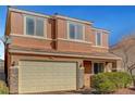 Two-story home with a neutral-toned exterior, a two-car garage, and manicured landscaping at 6190 Tillman Crest Ave, Las Vegas, NV 89139