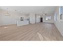 Open-concept living space featuring light hardwood floors, a kitchen island, and lots of natural light at 7505 Crystal Clear Ave, Las Vegas, NV 89113