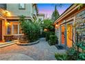 Charming entryway featuring stone accents, brick pavers, mature landscaping, and an inviting atmosphere perfect for any home at 801 Sir James Bridge Way, Las Vegas, NV 89145