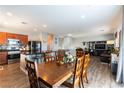 Open-concept living space featuring a kitchen island, dining area with wood table, and cozy living room at 10745 Leatherstocking Ave, Las Vegas, NV 89166