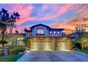 Beautiful two-story home with a three-car garage and stone accents, set against a colorful sky at 116 N Ring Dove Dr, Las Vegas, NV 89144