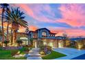 Beautiful two-story home with a lush landscaped yard highlighted by a colorful sunset backdrop at 116 N Ring Dove Dr, Las Vegas, NV 89144