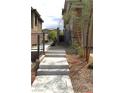 Well-maintained side yard featuring xeriscaping, a paved walkway, and a modern fence for privacy at 11703 Emerald Lake Ave, Las Vegas, NV 89138