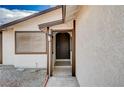 Inviting home entrance with a classic dark-colored door, textured walls and landscaped gravel at 1813 Pluto Dr, Las Vegas, NV 89108