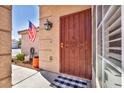 Inviting front door featuring a security gate, American flag, and well-maintained landscaping at 1842 Trigger Way, North Las Vegas, NV 89032