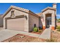 Charming single-story home with a two-car garage and neutral-toned exterior at 1842 Trigger Way, North Las Vegas, NV 89032