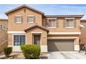 Two-story home with tan stucco, desert landscaping, a driveway, and an attached two-car garage at 1930 Silver Crest Ct, North Las Vegas, NV 89031