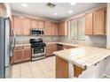 Traditional kitchen features tile countertops, stainless steel appliances, and wooden cabinets at 1930 Silver Crest Ct, North Las Vegas, NV 89031