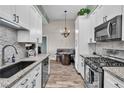 Well-lit kitchen with stone countertops, black appliances, and tile backsplash at 2305 W Horizon Ridge Pkwy # 322, Henderson, NV 89052