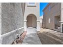 Inviting front entrance with an arched doorway and a well-manicured pathway at 232 Charitable Ct, North Las Vegas, NV 89032