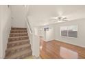Bright living room with hardwood floors, a ceiling fan, and a staircase at 232 Charitable Ct, North Las Vegas, NV 89032