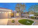 Beautiful single-story house featuring well-maintained landscaping with rock and a lovely patch of lawn at 2475 Hamonah Dr, Henderson, NV 89044