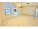 Spacious living room featuring neutral tile flooring, a ceiling fan and bright natural light at 254 Finestra Dr, Henderson, NV 89074