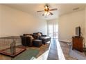 Relaxing living room featuring wood flooring, a ceiling fan, and a sliding glass door to the backyard at 2681 Benton Cove St, Laughlin, NV 89029
