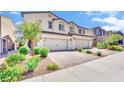 Beautiful two-story townhouse with attached garage and lush green landscaping at 310 Rain Quail Way, Henderson, NV 89012