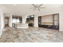 Open living room with stone floors, a fireplace, and modern light fixtures at 3914 Jacob Lake Cir, Las Vegas, NV 89118
