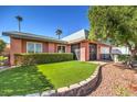 Beautiful single-story home with manicured lawn, rock landscaping, and mature palm trees at 4095 Ridgewood Ave, Las Vegas, NV 89120