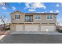 Townhome featuring a balcony and three garage doors, complemented by a landscaped yard at 4305 Morgan Manor St # 3, North Las Vegas, NV 89032