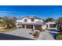 Spacious two-story home with a three-car garage, lush landscaping, and a concrete driveway at 4880 Hayride St, Las Vegas, NV 89149