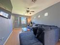 Inviting living room featuring a comfortable blue sectional sofa, ceiling fan, and natural light at 5288 Emelita St, Las Vegas, NV 89122