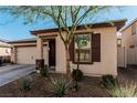 Charming single-story home featuring a two car garage, neutral stucco, and desert landscaping at 617 Abrazar Ave, North Las Vegas, NV 89081