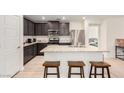 Modern kitchen with granite countertops, stainless steel appliances, and an island with bar seating at 617 Abrazar Ave, North Las Vegas, NV 89081