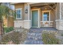 Inviting front porch with stone accents, seating, and a green door leading into the home at 690 Last Dance Pl, Henderson, NV 89011
