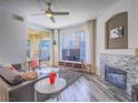 Bright living room featuring a ceiling fan, modern fireplace, and balcony access at 7111 S Durango Dr # 305, Las Vegas, NV 89113