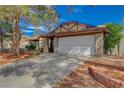 Wide driveway leads to an attached two-car garage, framed by mature trees and a tidy front yard at 872 Linn Ln, Las Vegas, NV 89110