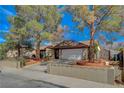 Charming home with a spacious driveway, two-car garage, and beautiful landscaping, all under a sunny sky at 872 Linn Ln, Las Vegas, NV 89110