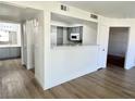 Open floor plan of living room with view into kitchen and hall to the bath at 1150 N Buffalo Dr # 1005, Las Vegas, NV 89128