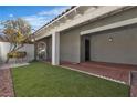 Inviting front porch with artificial grass, decorative rock, and a metal security gate at 2108 Plaza Del Dios, Las Vegas, NV 89102