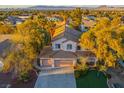 An attractive two-story home with a three-car garage and manicured lawn sits beneath mature trees at 2204 Ambermill Ct, Henderson, NV 89052