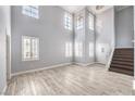 Spacious living area boasts wood-look flooring, large windows with shutters, and a staircase to the upper level at 2340 Hunt Club St, Las Vegas, NV 89128