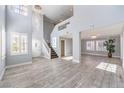 Bright, open-concept living room with soaring ceilings, wood-look flooring, and elegant chandelier lighting at 2340 Hunt Club St, Las Vegas, NV 89128