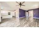 Spacious open-concept living room and kitchen area with modern wood flooring and sleek appliances at 3004 Moulin Heights St, Las Vegas, NV 89156