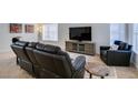 Comfortable living room featuring plush leather seating, a modern entertainment center, and lots of natural light at 486 Dart Brook Pl, Henderson, NV 89012