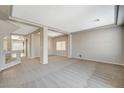 Open living room with neutral carpet, tray ceilings, recessed lights, and wide doorways to other rooms at 5309 Tartan Hill Ave, Las Vegas, NV 89141