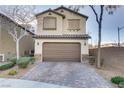 Two-story home with a two-car garage, a well maintained yard and a brick driveway at 6679 Salt Pond Bay St, Las Vegas, NV 89149