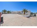 Expansive driveway leading to a two car garage with a desert landscape in front of the home at 736 N Kiel St, Henderson, NV 89015