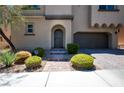 Close up of front exterior of stucco home featuring desert landscaping and a paver driveway at 9643 Ponderosa Skye Ct, Las Vegas, NV 89166