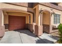 Attached garage with adjacent arched entry and manicured landscape at 11094 Arcadia Sunrise Dr, Henderson, NV 89052