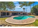 Inviting backyard with a kidney-shaped pool, surrounded by a brick-paved deck and lush landscaping at 1409 Bonita Ave, Las Vegas, NV 89104