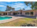 Backyard pool area with a kidney-shaped pool, brick-paved deck, and expansive sliding glass doors to the home at 1409 Bonita Ave, Las Vegas, NV 89104