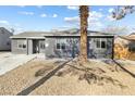 Single story home featuring gray exterior with well-kept gravel landscaping around a mature palm tree at 1417 Joshua Way, Las Vegas, NV 89101