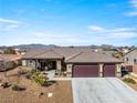 Beautiful single-story home featuring a spacious three-car garage, desert landscaping, and a welcoming front porch at 150 Spruce Ln, Pahrump, NV 89048