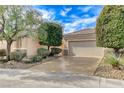 A view of a single story home, front-facing two car garage, desert landscaping, and shade trees at 2204 Bay Thrush Way, North Las Vegas, NV 89084