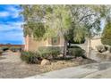 Single story home with a well-maintained front yard with mature tree and desert landscaping at 2204 Bay Thrush Way, North Las Vegas, NV 89084