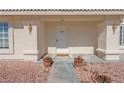 Charming front porch with decorative columns, a white door, and potted plants at 240 Ember St, Pahrump, NV 89048